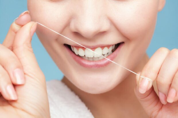 Lai noņemtu atlikumus starp zobiem, ieteicams izmantot zobu diegu.